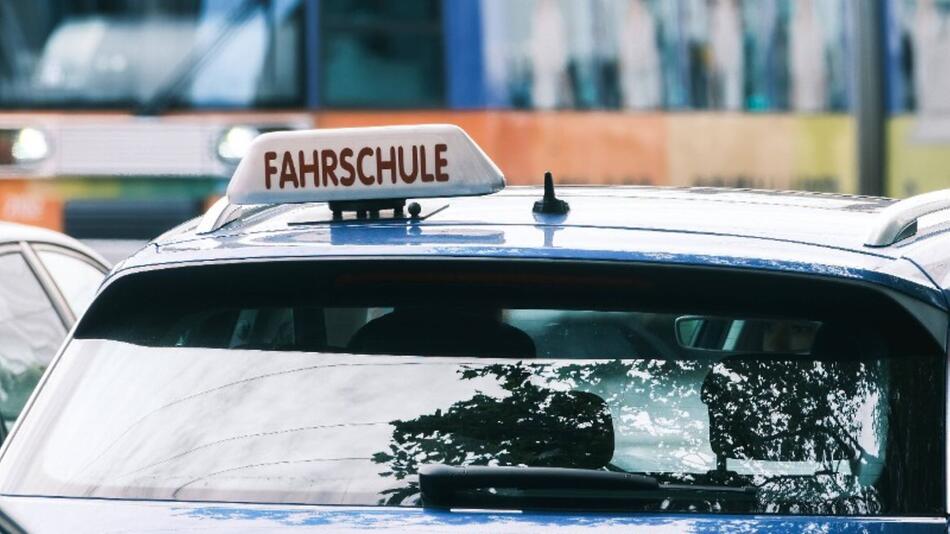 Ein Fahrschul-Auto parkt am Straßenrand.