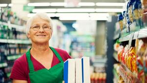 Foto einer Seniorin, die im Supermarkt arbeitet.