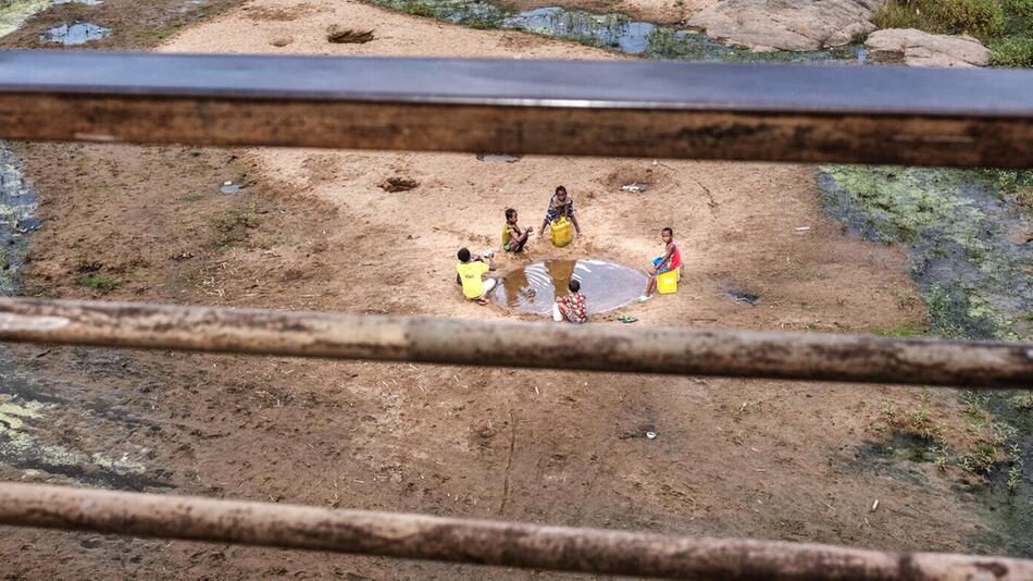 Kinder in einem fast ausgetrocknetem Flussbett