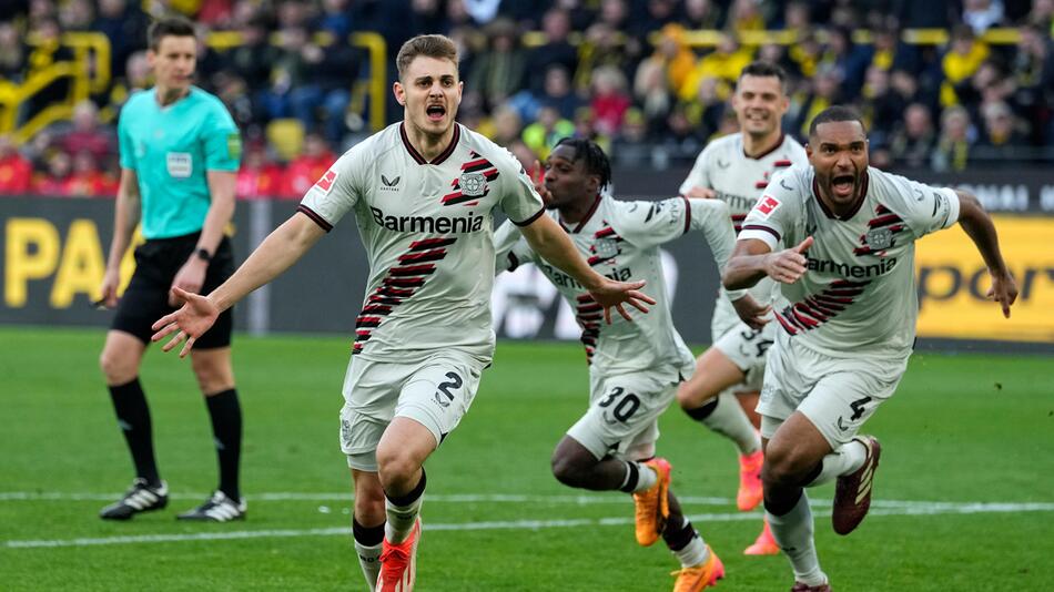 Leverkusens Josip Stanisic bjeubelt mit seinen Teamkollegen den späten Ausgleich in Dortmund