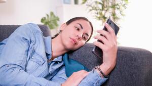 Eine Frau schaut enttäuscht auf ihr Handy.