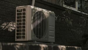 Eine Wärmepumpe an einer dunklen Hauswand