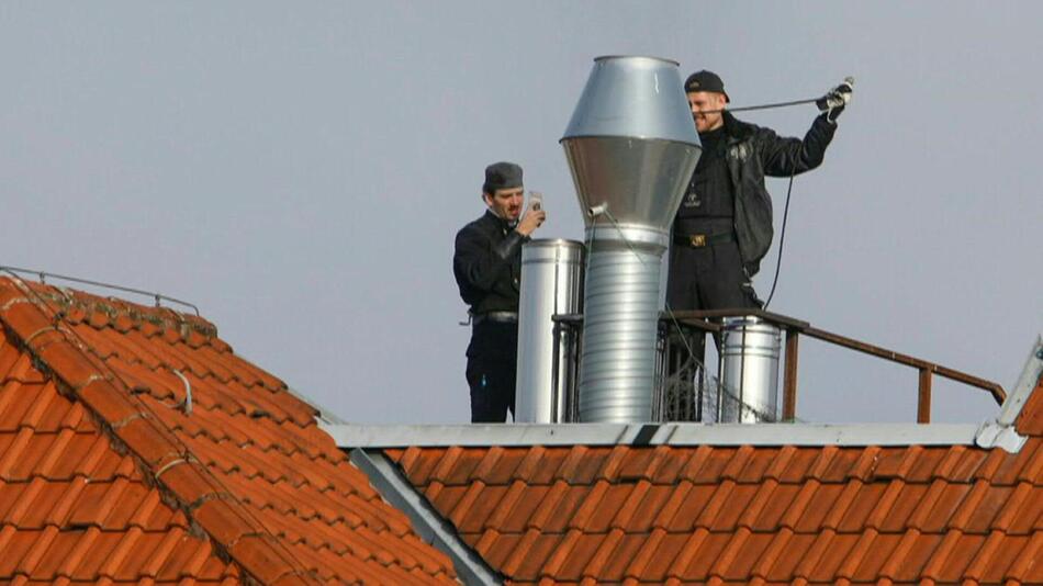 Schornsteinfeger auf dem Dach im Einsatz