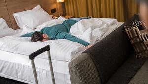 Ein Mann liegt erschöpft auf einem Bett in einem Hotelzimmer
