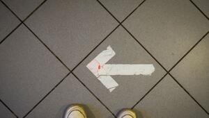 Ein Pfeil aus Klebeband ist auf einem Fußboden zu sehen