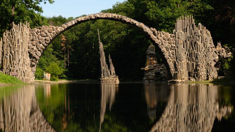 Die Rakotzbrücke, auch als Teufelsbrücke bekannt, spiegelt sich im Wasser.