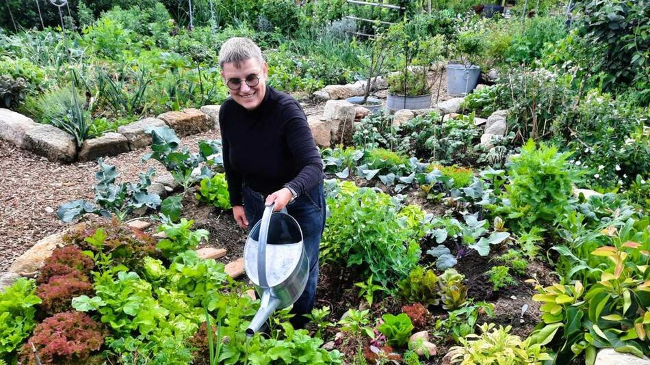 Antje Krüger steht in einem Kraterbeet
