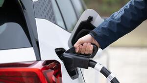 Ein Mann steckt ein Ladekabel in ein Elektroauto