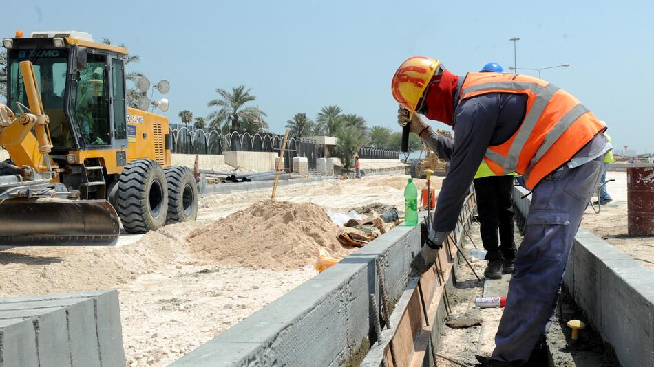 Am 4. Oktober 2013 bauen Arbeitsmigranten in Doha in Katar an einer Küstenstraße