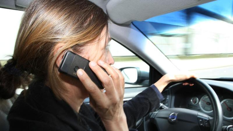 Autofahrerin mit Handy am Steuer