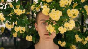 Eine Junge Frau hinter Blumen im Park