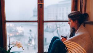 Frau schaut traurig aus dem Fenster 