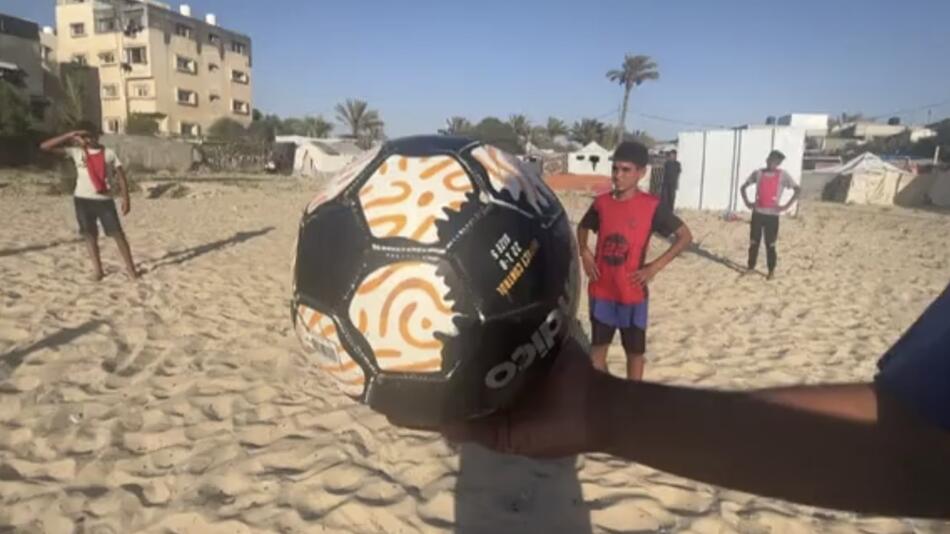 Kinder in Gaza spielen am Strand Fußball.