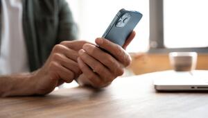 Jüngerer Mann mit Smartphone und Kreditkarte in der Hand