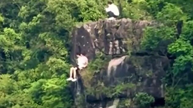 Riskante Aussicht: Ausflügler entspannen an Berg – dann zoomt die Kamera heraus
