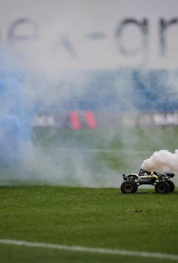 Autos mit Rauchtöpfen fahren auf dem Spielfeld des FC Hansa Rostock.