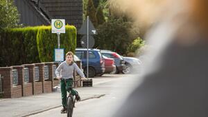 Junge fährt mit dem Fahhrad auf einer Straße