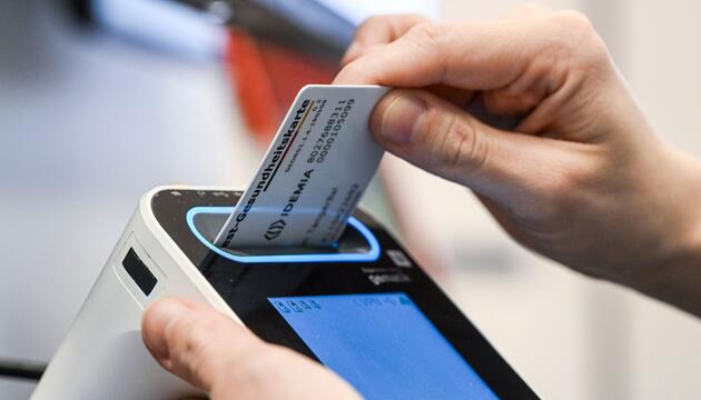 Eine Gesundheitskarte wird in ein Lesegerät geschoben