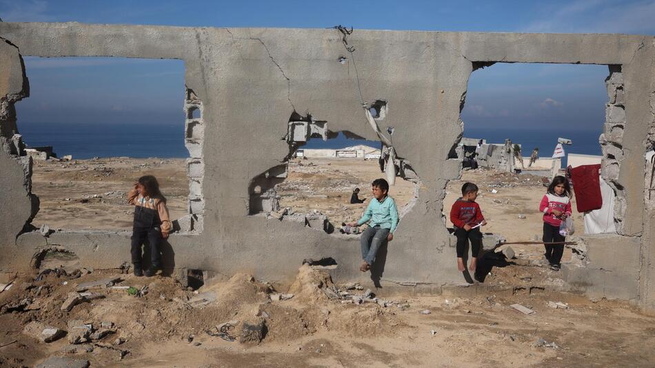 Kinder vor einem zerstörten Haus