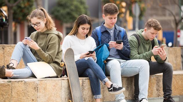 Jugendliche chatten auf ihrem Smartphon
