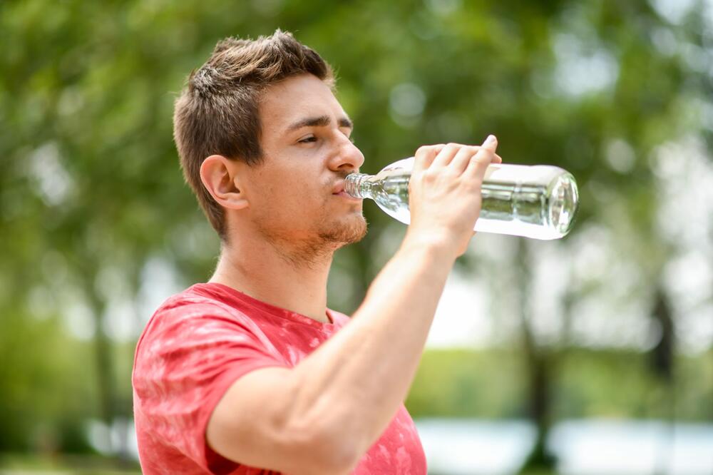 Ein Mann trinkt Mineralwasser