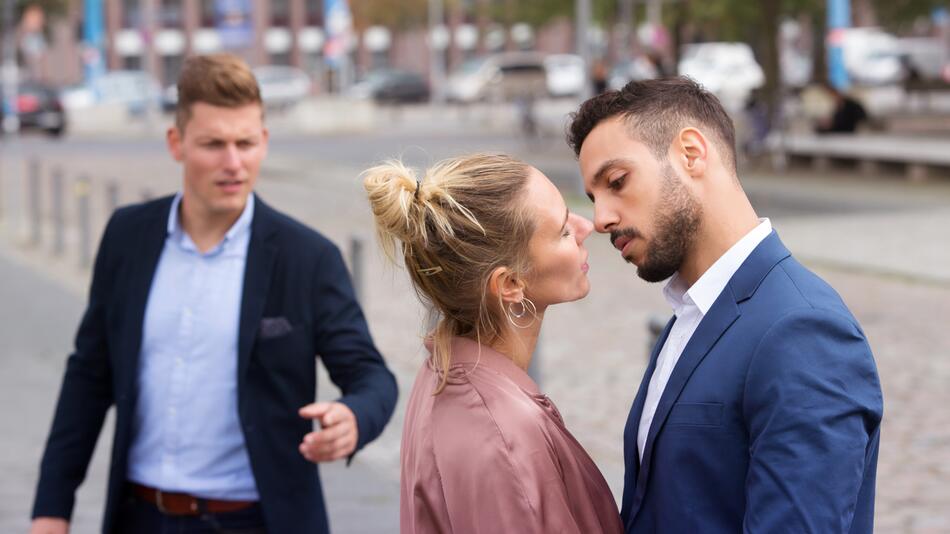 Frau küsst anderen Mann