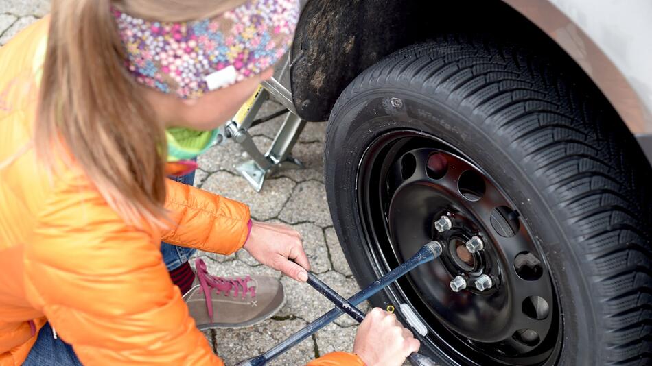 Eine Frau wechselt Autoräder