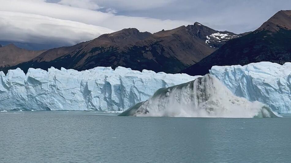 Vor dem Perito-Moreno-Gletscher in Argentinien taucht plötzlich ein Eisberg aus dem Wasser auf.