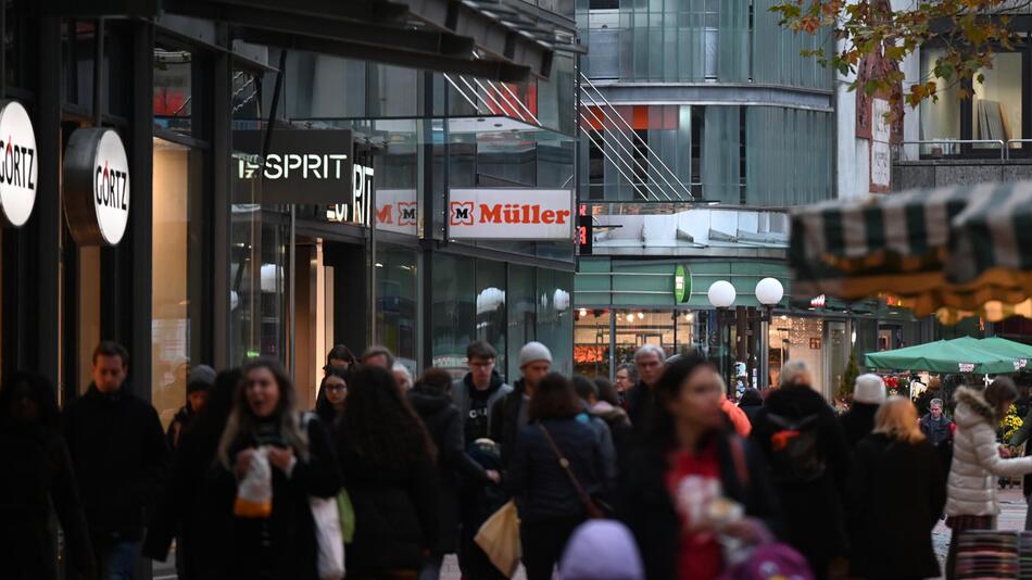 Passanten laufen durch eine Einkaufsstraße in Hamburg