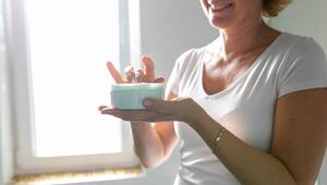 Frau cremt sich ein, Finger in der Creme