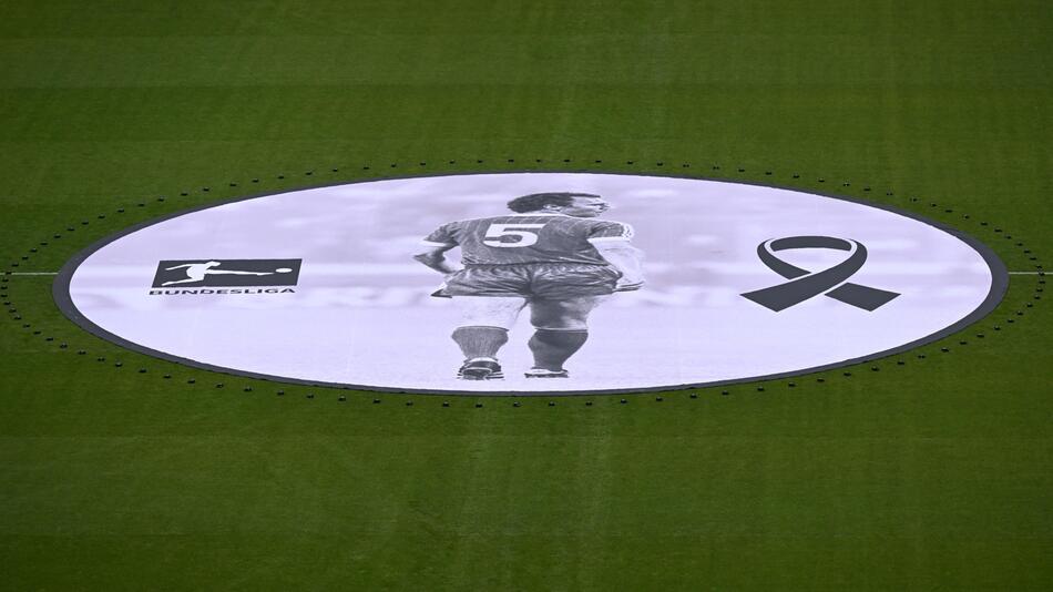 Ein überdimensionales Bild Franz Beckenbauers liegt während der Gedenkfeier für ihn auf dem Rasen