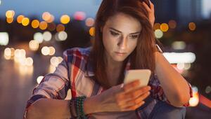 Eine Frau schaut traurig auf ihr Handy.