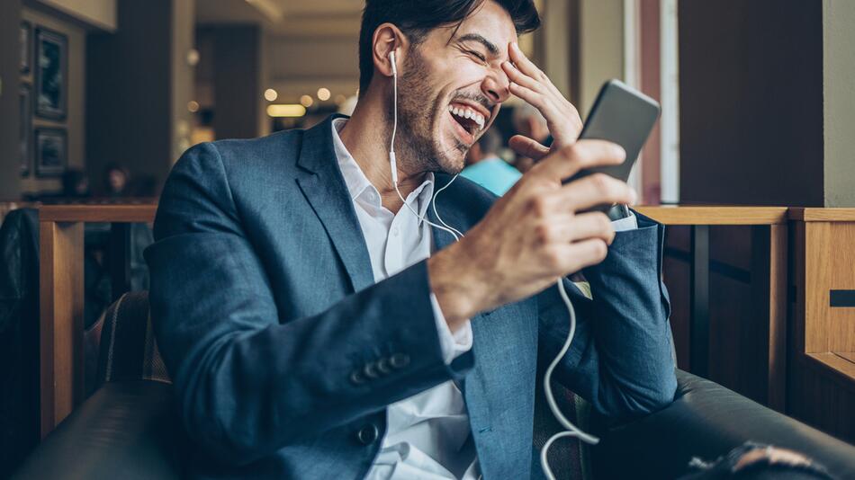 Mann lacht am Telefon