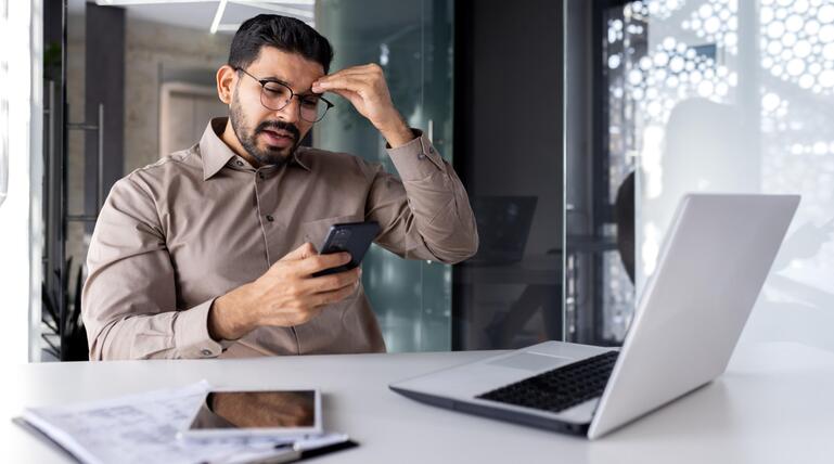 Mann regt sich auf, ist am Smartphone