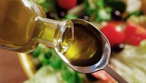 Olivenöl wird auf einen Löffel geschüttet.