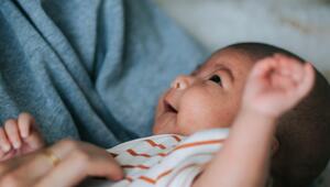 Mutter, die ein lachendes Baby auf dem Arm hält. 