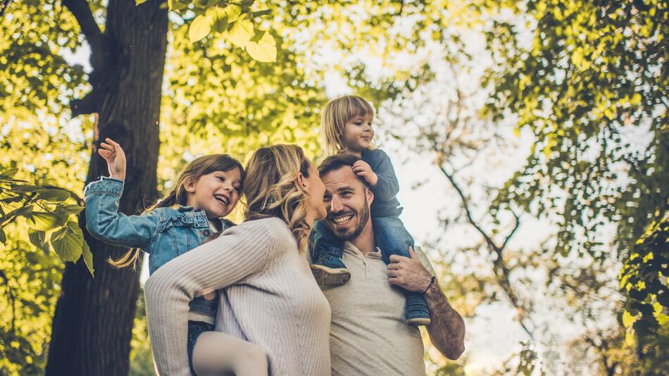 Eltern mit ihren zwei Kindern sind im Wald