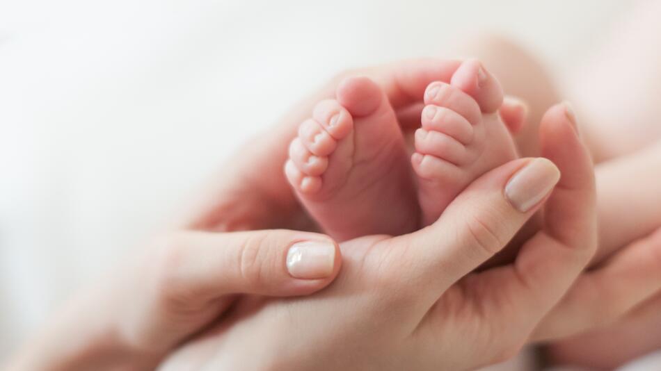 Hände halten Babyfüße