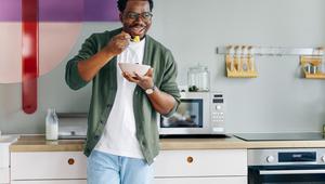 Mann in der Küche mit Teller Essen