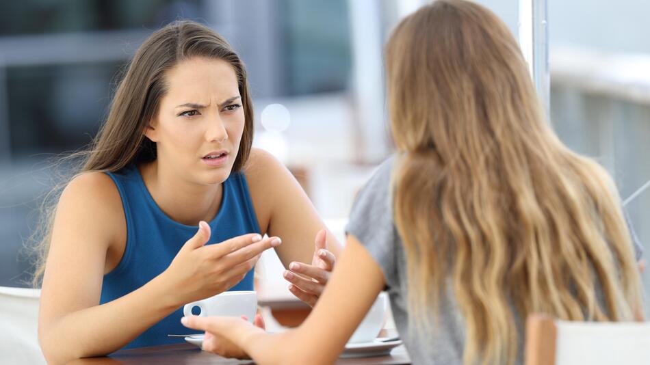Zwei Frauen diskutieren im Cafe.