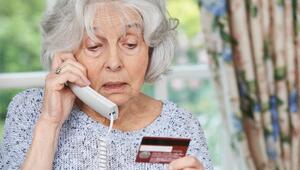 Seniorin am Telefon mit Bankkarte in der Hand