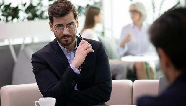 Geschäftsmann blickt sein Gegenüber kritisch an