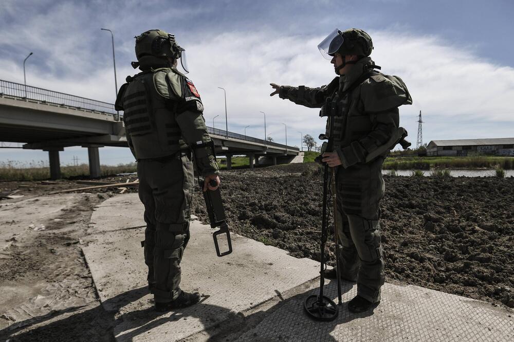 Zwei Soldaten stehen vor einer Brücke.