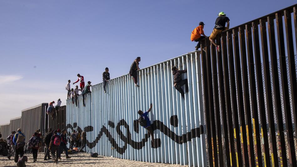 Mitglieder der Migrantenkarawane erreichen die Grenzmauer