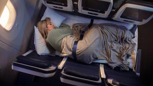 Eine Frau liegt auf drei Sitzen im Flugzeug