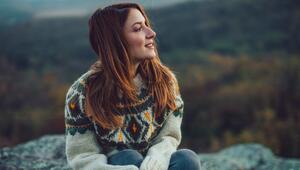 Frau schaut selbstbewusst in die herbstliche Landschaft