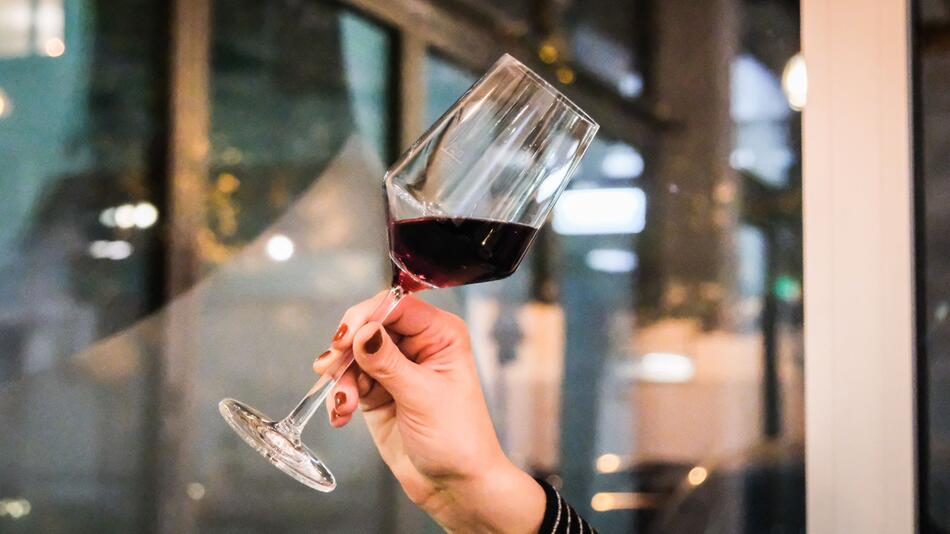 Eine Frau hält ein Glas Rotwein in der Hand